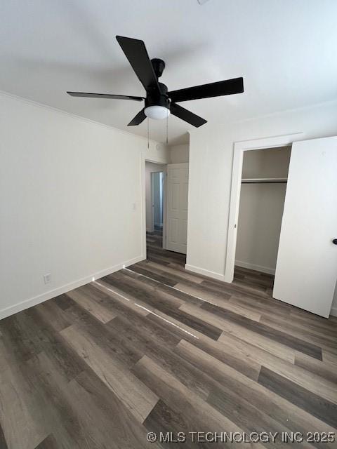 unfurnished bedroom with ceiling fan, dark hardwood / wood-style flooring, and a closet