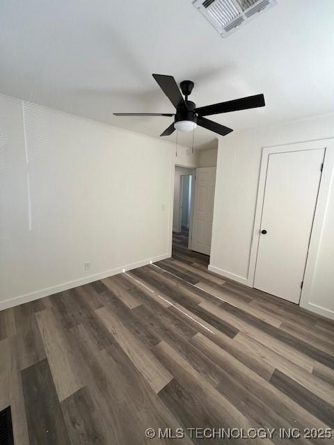 spare room with dark hardwood / wood-style floors and ceiling fan