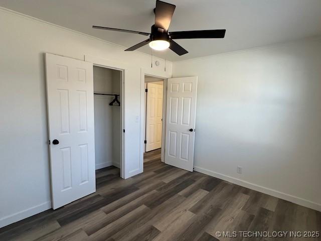 unfurnished bedroom featuring dark hardwood / wood-style floors, a closet, and ceiling fan