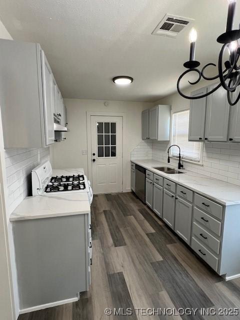 kitchen featuring dark hardwood / wood-style flooring, stainless steel dishwasher, sink, range, and gray cabinets