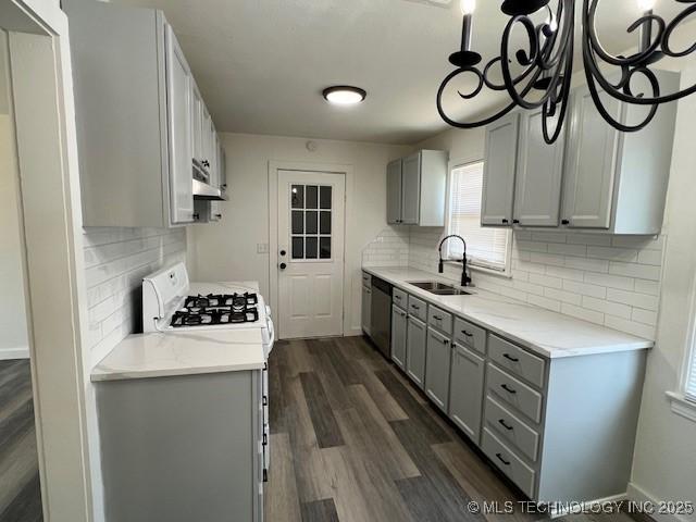 kitchen featuring dishwasher, dark wood-type flooring, white gas range oven, sink, and gray cabinets