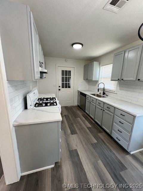 kitchen with stove, dark wood-type flooring, sink, stainless steel dishwasher, and gray cabinets