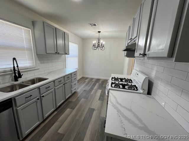 kitchen featuring sink, stainless steel dishwasher, decorative backsplash, gray cabinets, and decorative light fixtures