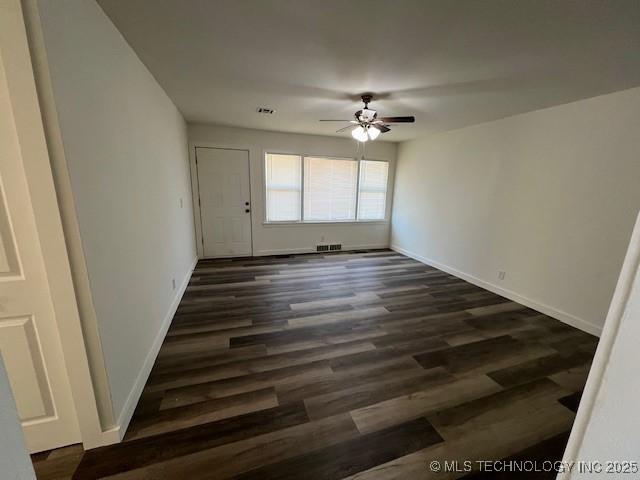 spare room featuring ceiling fan and dark wood-type flooring