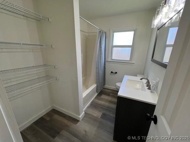 full bathroom with hardwood / wood-style flooring, vanity, toilet, and shower / bath combo with shower curtain