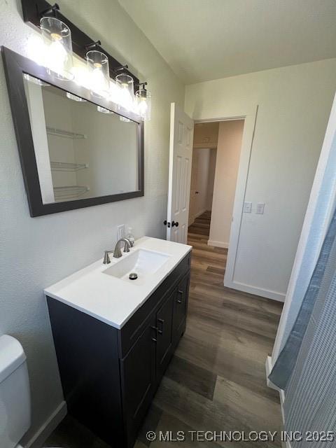 bathroom featuring vanity, toilet, and wood-type flooring