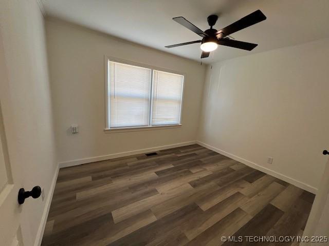 empty room with dark hardwood / wood-style floors and ceiling fan