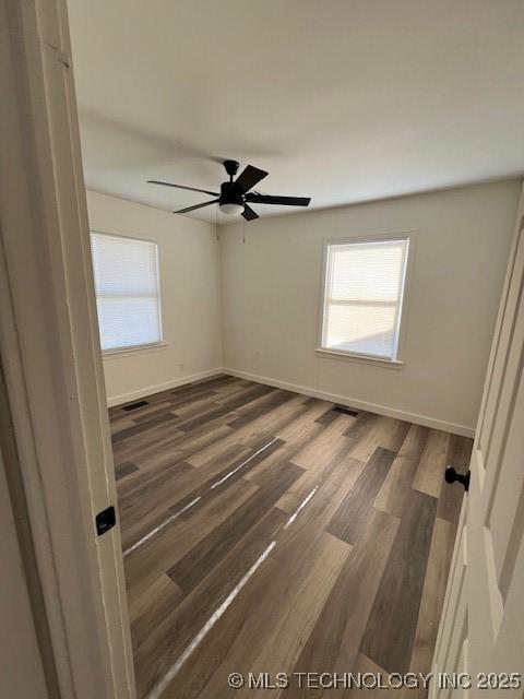 empty room featuring ceiling fan and dark wood-type flooring