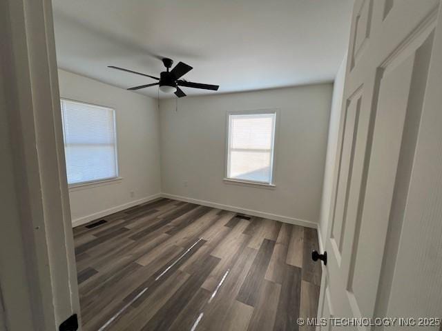 spare room with ceiling fan and dark wood-type flooring