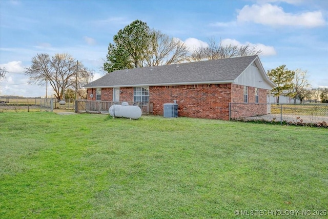 rear view of house with a yard and central AC unit