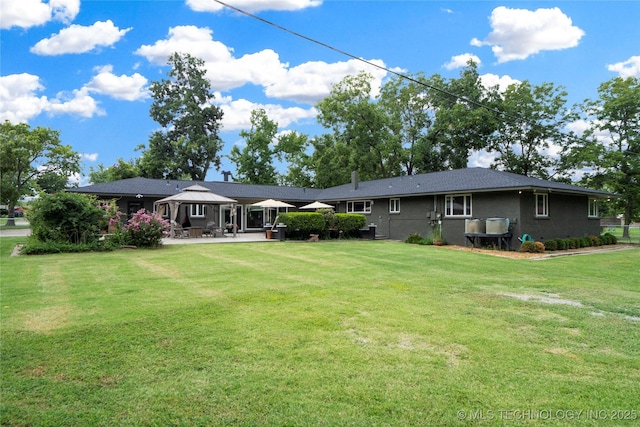 rear view of house featuring a gazebo, a yard, and a patio