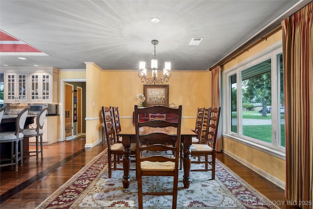 dining space with a notable chandelier, dark hardwood / wood-style flooring, and ornamental molding