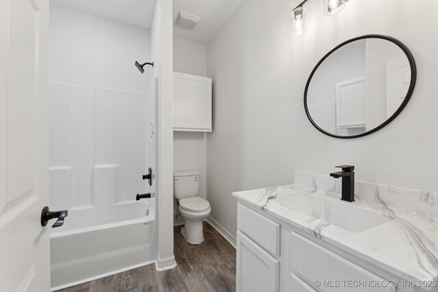 full bathroom featuring vanity, toilet, bathtub / shower combination, baseboards, and wood finished floors