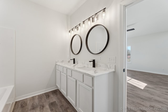 bathroom with hardwood / wood-style flooring, vanity, and a washtub