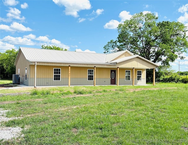 view of front of property with metal roof, a front yard, and central air condition unit