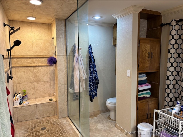 bathroom with baseboards, a shower stall, toilet, and crown molding