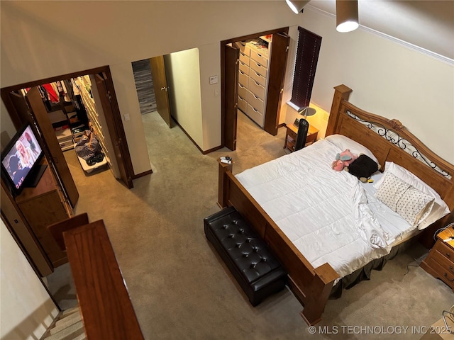 bedroom with baseboards and light colored carpet