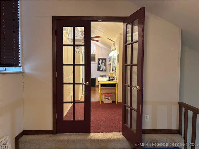 corridor with lofted ceiling, french doors, carpet flooring, and baseboards