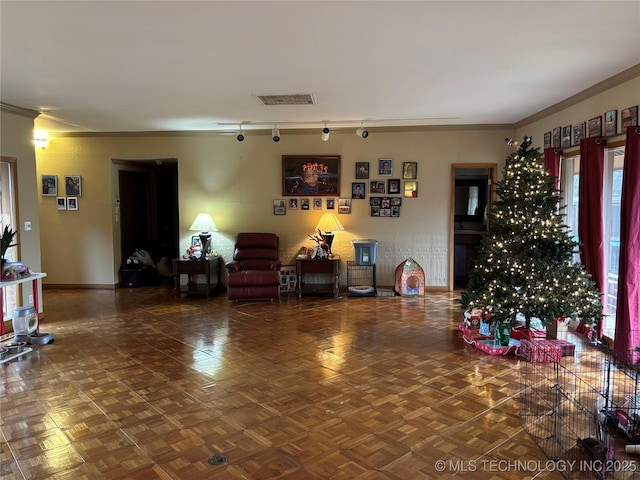 interior space with parquet flooring, track lighting, and crown molding