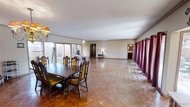 dining area featuring a chandelier, baseboards, and crown molding