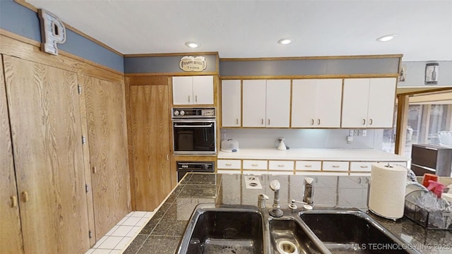 kitchen featuring dobule oven black, white cabinets, backsplash, a sink, and recessed lighting