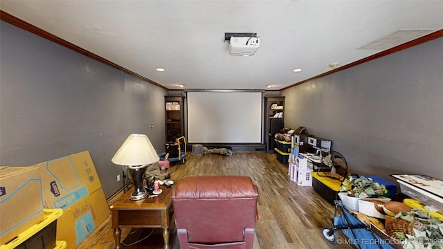 home theater with recessed lighting, crown molding, and wood finished floors