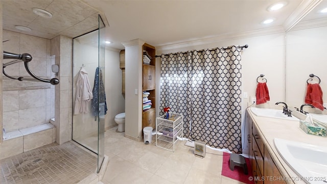 full bathroom featuring toilet, a sink, ornamental molding, a tile shower, and double vanity