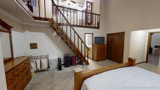 bedroom with a high ceiling and light colored carpet