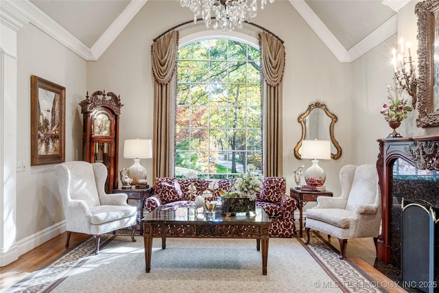 sitting room with an inviting chandelier, wood-type flooring, vaulted ceiling, and ornamental molding