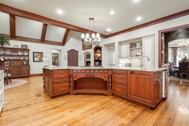 kitchen featuring pendant lighting, sink, a notable chandelier, light hardwood / wood-style floors, and light stone counters