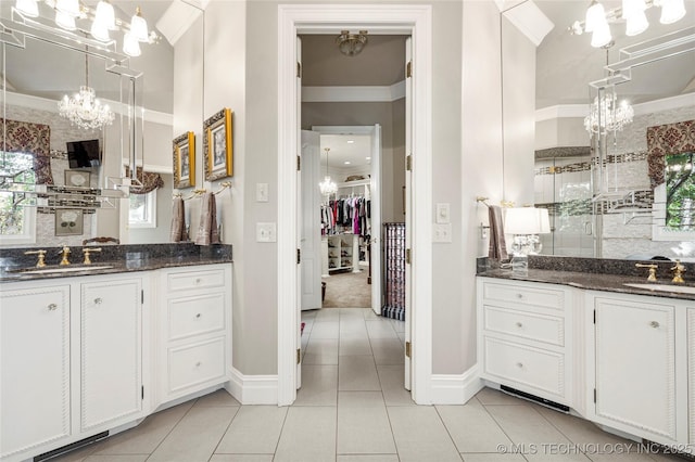 bathroom featuring tile patterned flooring, vanity, crown molding, and a notable chandelier