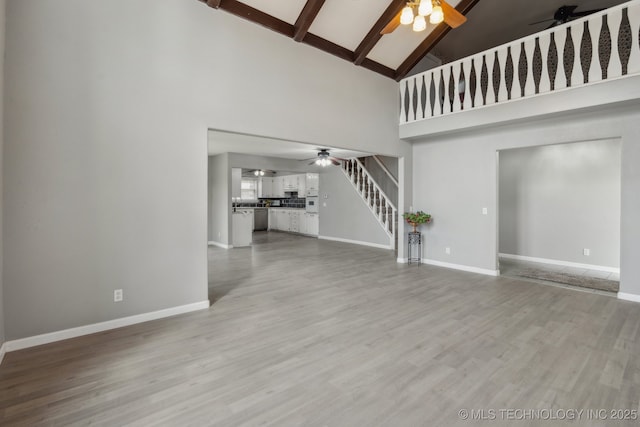 201 Sandy Cir, Tahlequah, OK 74464 - unfurnished living room with ceiling fan, stairway, high vaulted ceiling, beamed ceiling, and baseboards