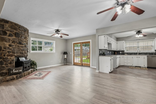201 Sandy Cir, Tahlequah, OK 74464 - unfurnished living room featuring a wood stove, plenty of natural light, and ceiling fan