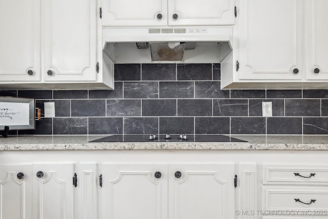 201 Sandy Cir, Tahlequah, OK 74464 - kitchen featuring white cabinetry, under cabinet range hood, tasteful backsplash, black electric stovetop, and light stone countertops