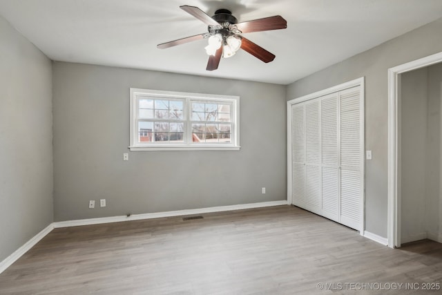 201 Sandy Cir, Tahlequah, OK 74464 - unfurnished bedroom featuring wood finished floors, a closet, baseboards, and a ceiling fan