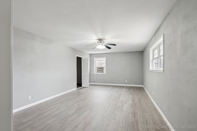 unfurnished room featuring hardwood / wood-style flooring, ceiling fan, and a textured ceiling