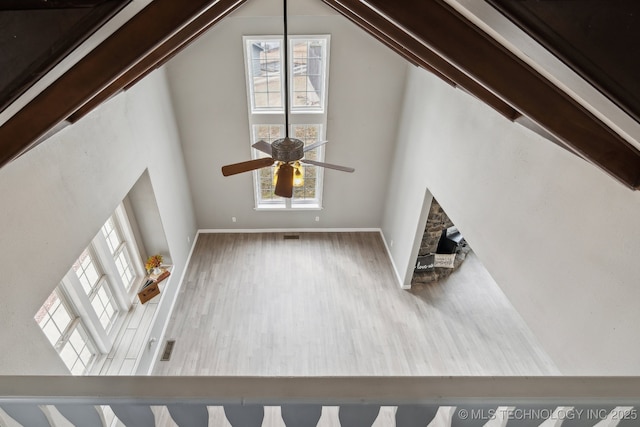 unfurnished living room with ceiling fan, high vaulted ceiling, a fireplace, and hardwood / wood-style floors