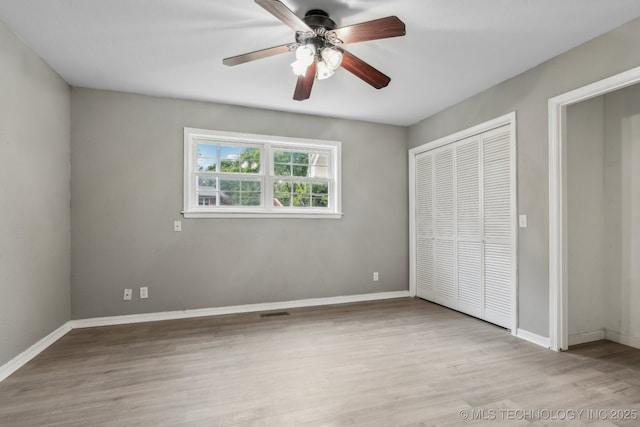 201 Sandy Cir, Tahlequah, OK 74464 - unfurnished bedroom with a closet, baseboards, wood finished floors, and a ceiling fan
