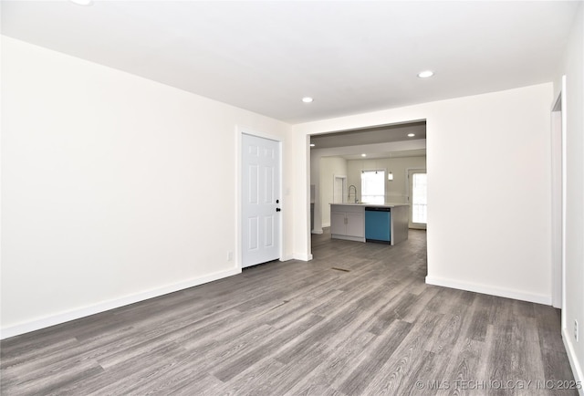 spare room featuring sink and dark wood-type flooring