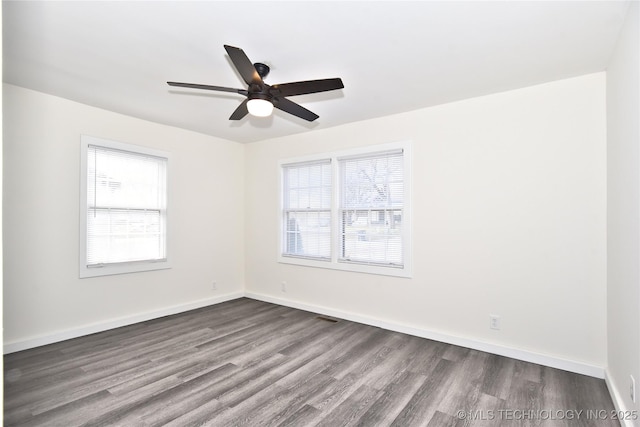 empty room featuring ceiling fan, a healthy amount of sunlight, and hardwood / wood-style flooring