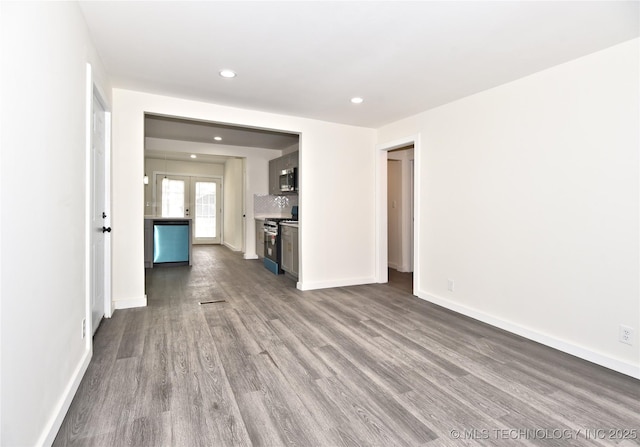 unfurnished living room with hardwood / wood-style floors and french doors