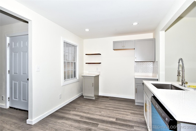 kitchen with gray cabinetry, dark wood-type flooring, sink, stainless steel dishwasher, and decorative backsplash