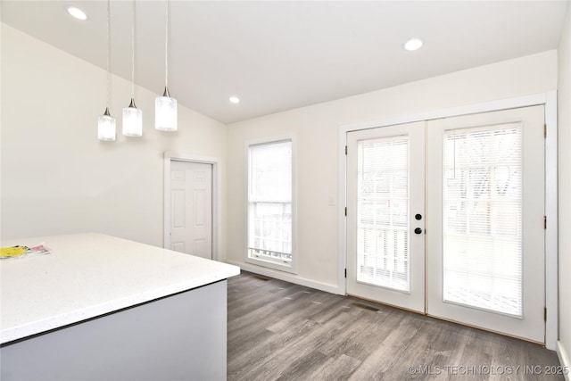 kitchen featuring pendant lighting, hardwood / wood-style flooring, and french doors