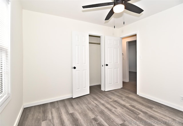 unfurnished bedroom with ceiling fan, a closet, and wood-type flooring