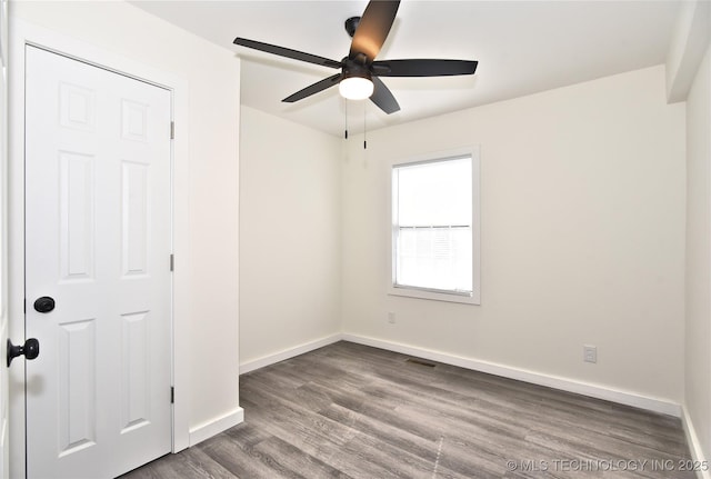 unfurnished room with ceiling fan and dark wood-type flooring