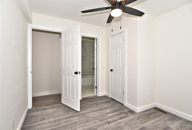 unfurnished bedroom with a closet, hardwood / wood-style flooring, ceiling fan, and connected bathroom