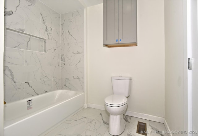 bathroom featuring tiled shower / bath combo and toilet