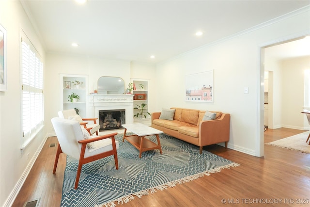 living room featuring hardwood / wood-style floors, built in features, and a wealth of natural light