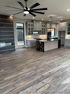 kitchen featuring wood-type flooring, a center island, and backsplash