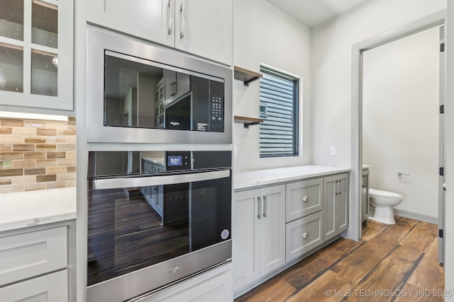 425 W Ft Worth St, Broken Arrow, OK 74012 - kitchen featuring built in microwave, oven, light stone countertops, tasteful backsplash, and dark wood-style flooring